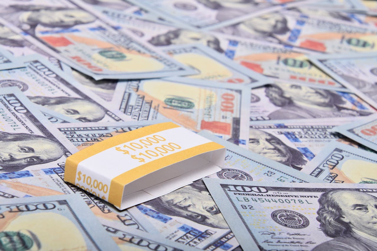 A stack of 00 bills arranged on a surface with US dollar notes. Ideal for finance themes.